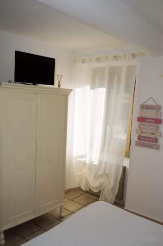 a living room with a tv and a window at carugio del fezzano in Fezzano