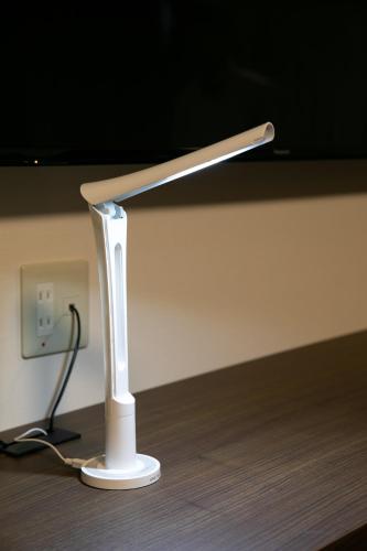 a white nintendo wii remote sitting on a wooden floor at Hotel Silk Tree Nagoya in Nagoya