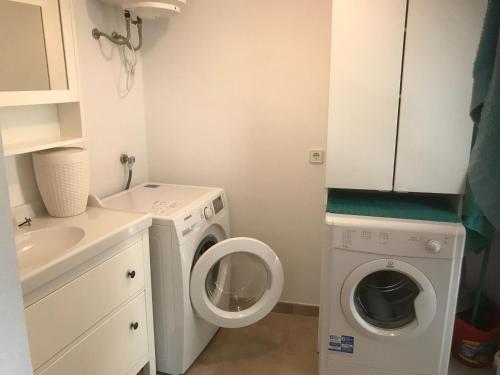 a small bathroom with a washing machine and a sink at Ca Na Clar in Sa Ràpita