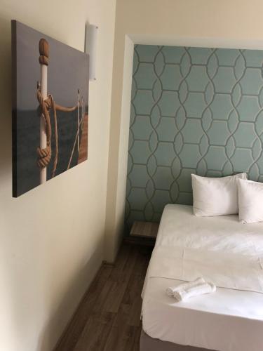 エフォリエ・スドにあるAnna by the Seaのベッド2台が備わる客室で、壁には絵画が飾られています。