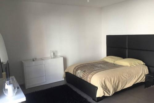 Schlafzimmer mit einem großen Bett mit einem schwarzen Kopfteil in der Unterkunft Centre ville Colmar, parking in Colmar