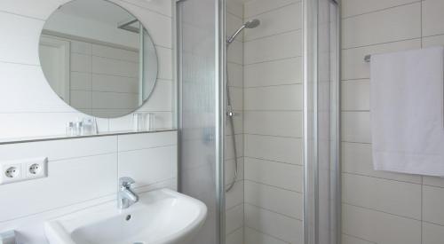 a white bathroom with a sink and a mirror at Goldene Traube in Senden