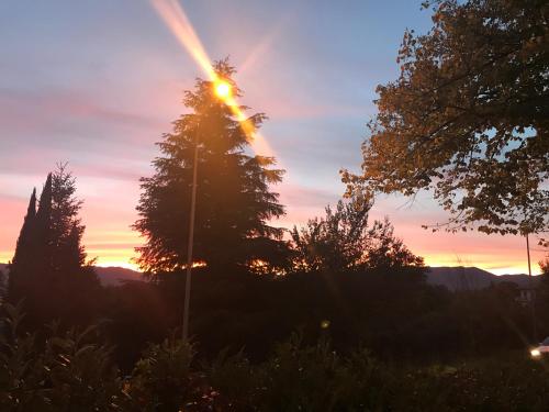 a sunset with a tree in the foreground at Stella Polare B&B in Rieti