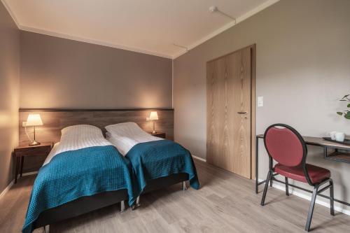 a bedroom with a bed and a desk and a chair at Holt Inn in Flateyri