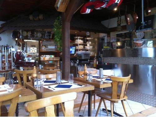 a restaurant with wooden tables and chairs and a bar at Hotel Central in Sursee