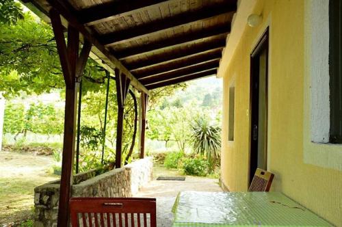 een veranda van een huis met een tafel en stoelen bij Ivan's Holiday Home in Virpazar