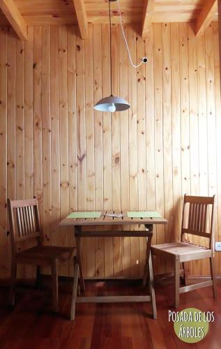 a wooden room with a table and two chairs at Posada de los Árboles in Eldorado