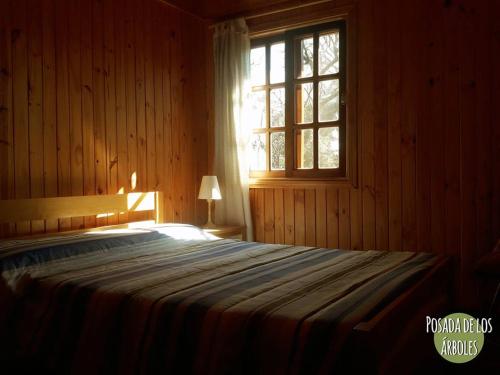 a bedroom with a large bed with a window at Posada de los Árboles in Eldorado