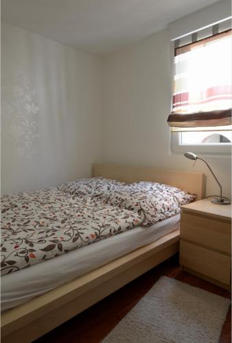 a bedroom with a bed and a window and a lamp at Ferienhaus Moselblick mit kostenfreien ÖPNV-Ticket in Ürzig