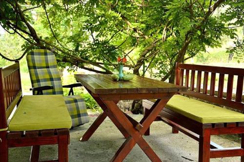 uma mesa de madeira e duas cadeiras e uma mesa e banco em Ivan's Holiday Home em Virpazar