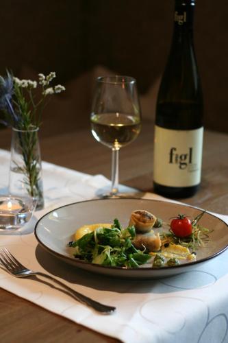 a plate of food and a glass of wine on a table at Hotel-Restaurant Stefanihof in Fuschl am See