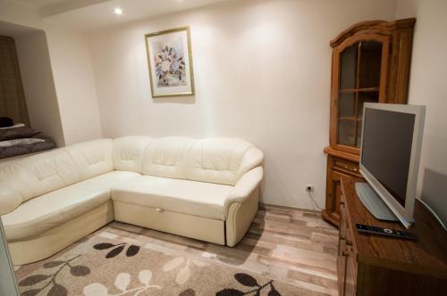 a living room with a white couch and a flat screen tv at Zankovecka 3 in Uzhhorod