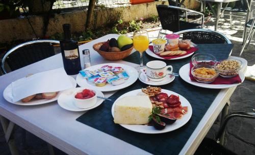 ein Tisch mit Tellern voller Speisen und Getränken in der Unterkunft AT Restaurante El Palacil in Vélez-Blanco