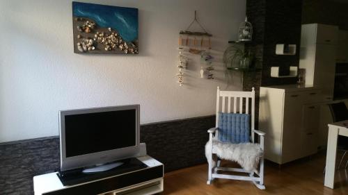 a living room with a tv and a chair at Ferienappartment "Mili am See" in Lochau