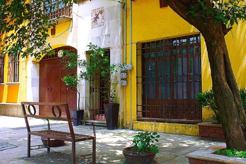 墨西哥城的住宿－Calle Berlin Boutique，坐在黄色建筑前面的长凳