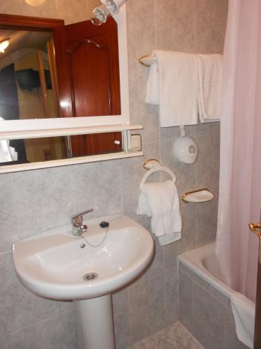 a bathroom with a sink and a bath tub at Alojamiento casa pepe in Soto de Cangas