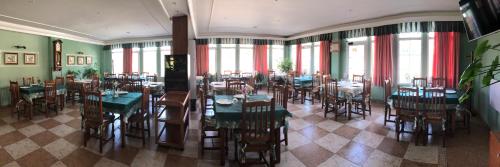 a dining room with tables and chairs and windows at Hostal Sanpatiel in Polientes