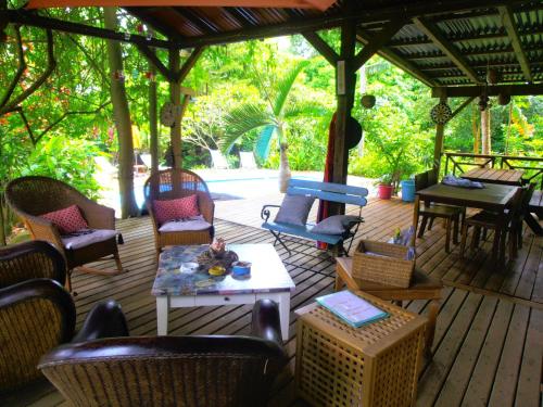 a patio with chairs and a table on a deck at Les Manguiers in Deshaies