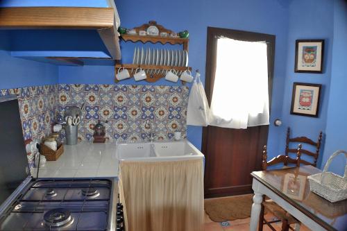 a blue kitchen with a stove and a sink at Casa Azul in Alozaina