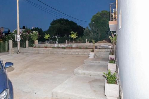 a parking lot with concrete steps with flowers and a building at Apartments Tina in Utjeha