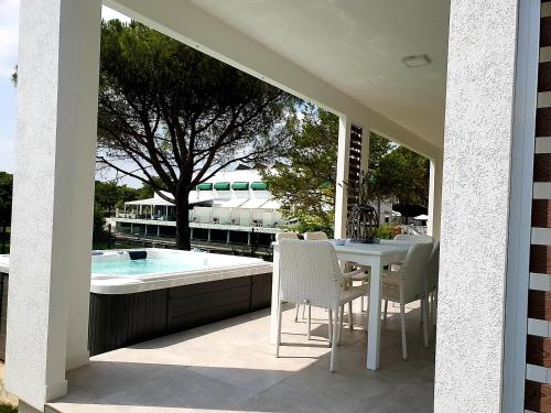 a patio with a table and chairs and a swimming pool at Villaggio La Pescaccia in San Clemente