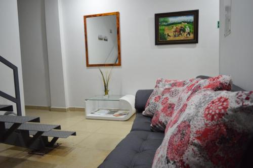 a living room with a couch and a mirror at Hotel Gran Palacio in Pereira