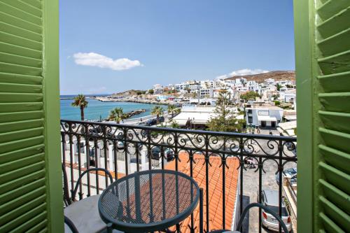 a balcony with a table and chairs and a view of a city at Aegli 1876 in Tinos Town
