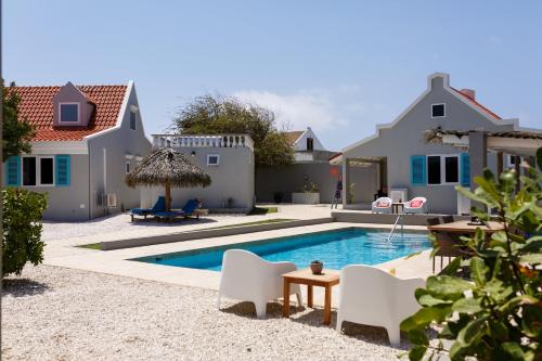 a villa with a swimming pool and a house at Aruba Boutique Apartments - Adults Only in Noord