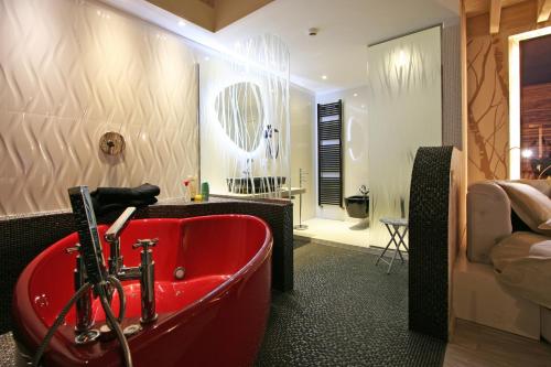 ein Bad mit einer roten Badewanne in einem Zimmer in der Unterkunft Ecohotel Primavera in Riva del Garda