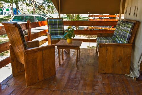 a porch with two chairs and a table with a potted plant at SunFlower Camping Savudrija in Savudrija