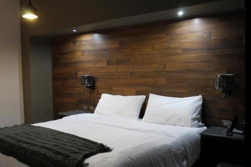 a bedroom with a large bed with a wooden headboard at Grand Marques in San Juan de los Lagos