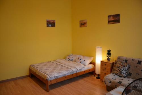 1 dormitorio con 1 cama y 1 silla en Miracool Apartament, en Cracovia