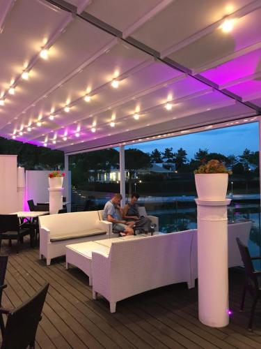 two people sitting on a deck at night with lights at Villaggio La Pescaccia in San Clemente