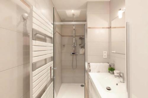 une salle de bain blanche avec une douche et un lavabo dans l'établissement PALAIS MIRAMAR CROISETTE APART 1 MIN CARLTON, à Cannes