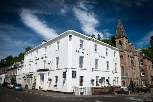 a large building with a clock on the front of it at Atholl Arms Hotel Dunkeld in Dunkeld