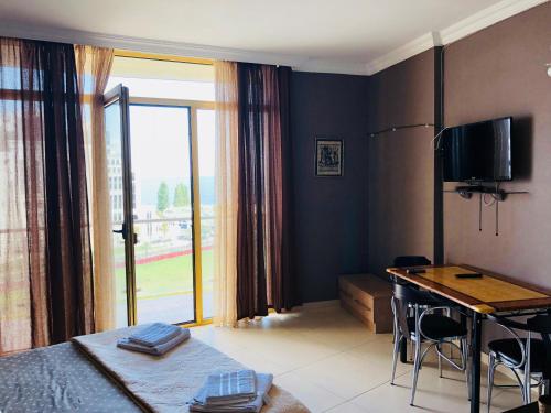 a bedroom with a bed and a desk with a desk at Orbi Plaza Apartment in Batumi