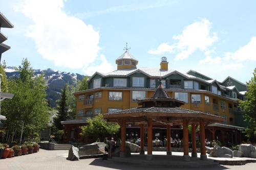 a large yellow building with a gazebo in front of it at Town Plaza Suites in Whistler