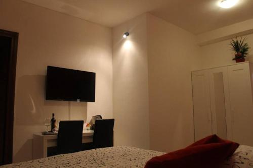 een slaapkamer met een bureau en een televisie aan de muur bij Amelia 5 in Rome