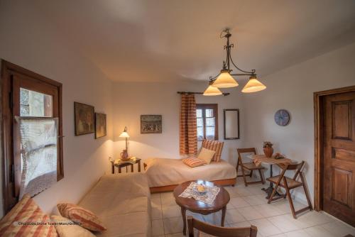 a bedroom with a bed and a living room at Charouda Stone Tower in Pyrgos Dirou