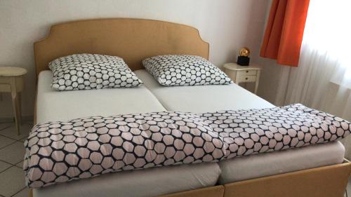 伍珀塔爾的住宿－2 Zimmer Wohnung Wuppertal mit Terrasse，卧室内的一张带两个枕头的床