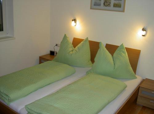 - une chambre avec 2 lits et des oreillers verts dans l'établissement Appartement Christopherus, à Pettneu am Arlberg