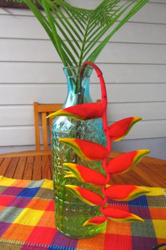 a vase with birds painted on it sitting on a table at Or bleu-Bungalow volcan Soufriere-Vue sur mer in Saint-Claude