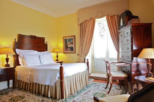 a bedroom with a bed and a desk and a window at Casa da Alcacova - Santarém in Santarém