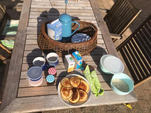 uma mesa com um prato de comida e um cesto de comida em Treehouse B&B em Rabjerg