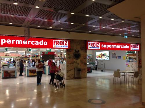 a store with people walking around in a shopping mall at Boavista YourHome in Porto