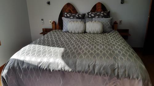 a bed with a gray comforter and pillows at Bruntwoodlodge in Cambridge