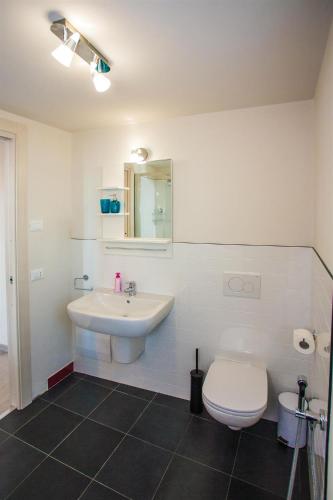 a white bathroom with a sink and a toilet at Garda Friends Apartments in Toscolano Maderno