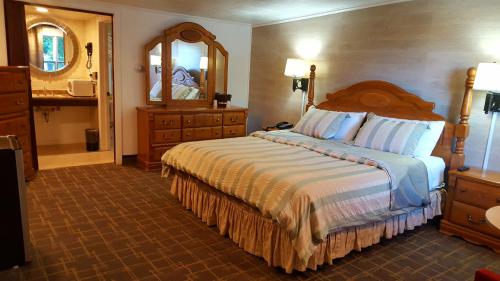 1 dormitorio con 1 cama grande y espejo en Stucco Lodge, en Bangor