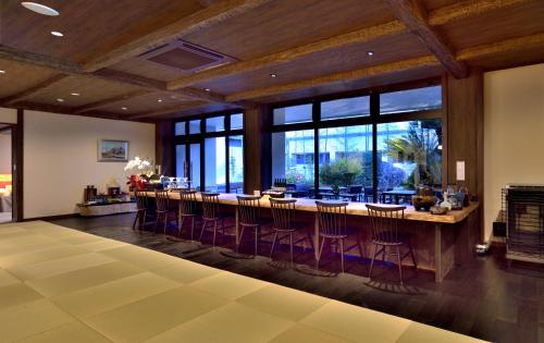 a large room with a long bar with purple bar stools at Kafutei in Yamaga