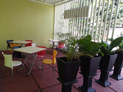 a room with tables and chairs and plants at de' GREEN Cibubur in Cibubur